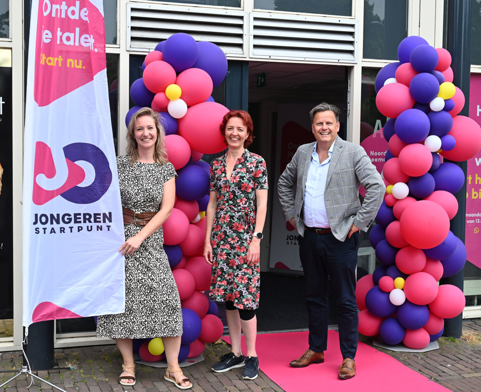 Medewerkers bij de versierde ingang van het geopende Jongeren Startpunt 
