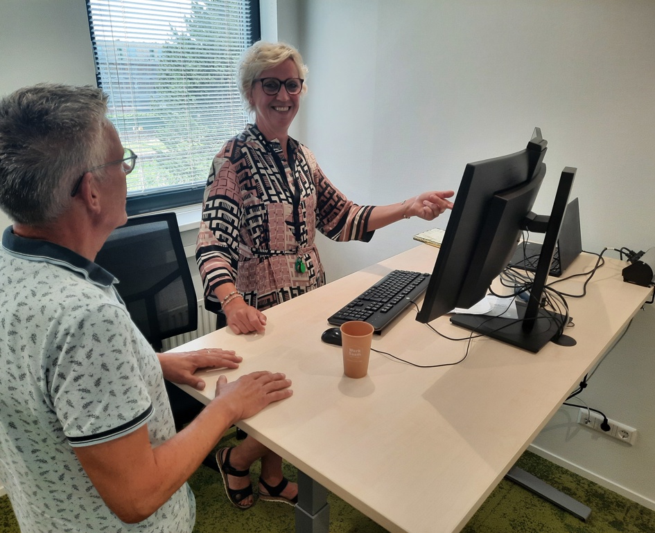 Twee collega's in gesprek bij computer